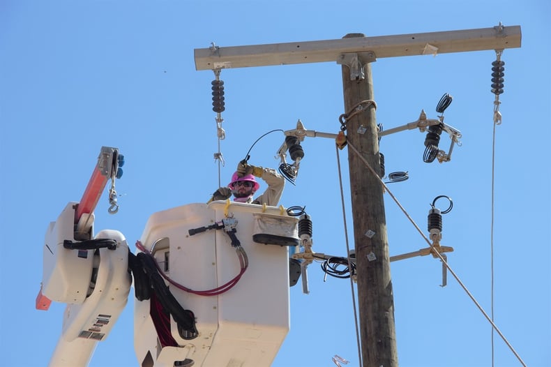 A Shreveport line mechanic installs new equipment on a pole near Line Avenue.