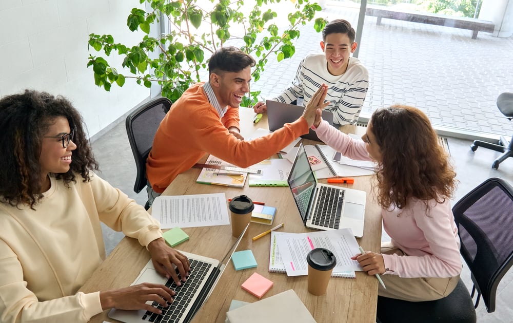 Happy employees highfiving in an office