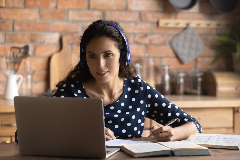 Woman wearing headphones looking at a laptop